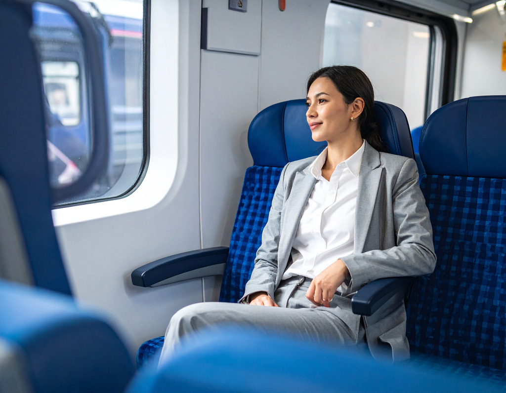 Image shows a lady sitting confidently on a train, having overcome her panic attacks